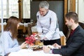 Chef presents them the second course to a couple in the restaurant. Royalty Free Stock Photo