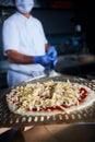 Chef  with protective coronavirus face mask preparing pizza Royalty Free Stock Photo