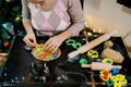 Chef puts colorful cookie cutters on the raw dough on the table. Cropped