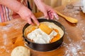 Chef puts cottage cheese in a mold to prepare apricot cheesecake