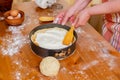 Chef puts cottage cheese in a mold to prepare apricot cheesecake