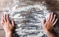 Chef puts hands on wooden table covered with baking flour thinking what to cook