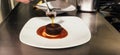 Chef putting the finishing touch on dessert plate while working in a restaurant kitchen. Royalty Free Stock Photo