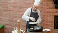 Chef putting fresh seafood to a pan