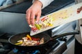 Chef putting ingredients to pan in restaurant kitchen Royalty Free Stock Photo