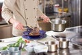 Chef putting lamb shank in plate.