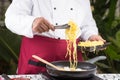 Chef putting noodle with tongs