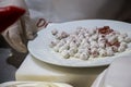 Chef putting raw meatballs in a plate with flour