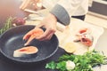 Chef putting salmon fish on pan for cooking