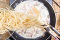 Chef putting Spaghetti carbonara to pan with tongs Royalty Free Stock Photo