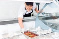 Chef replenishing a tray of food in a display Royalty Free Stock Photo