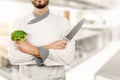 Chef in restaurant kitchen with broccoli and knife in hands Royalty Free Stock Photo