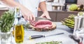 Chef in restaurant kitchen cooking,he is cutting meat or steak