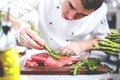 Chef in restaurant kitchen cooking,he is cutting meat or steak Royalty Free Stock Photo