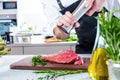 Chef in restaurant kitchen cooking,he is cutting meat or steak Royalty Free Stock Photo