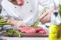 Chef in restaurant kitchen cooking,he is cutting meat or steak Royalty Free Stock Photo