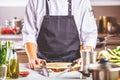 Chef in restaurant kitchen cooking,he is cutting meat or steak Royalty Free Stock Photo
