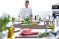 Chef in restaurant kitchen cooking,he is cutting meat or steak Royalty Free Stock Photo