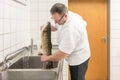 Chef gutting carp fish to prepare it later