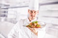 Chef in restaurant kitchen holding plate with italian meal spagh Royalty Free Stock Photo