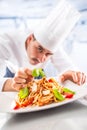 Chef in restaurant kitchen prepares and decorates meal with hands.Cook preparing spaghetti bolognese Royalty Free Stock Photo