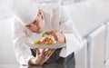 Chef in restaurant kitchen prepares and decorates meal with hands.Cook preparing spaghetti bolognese Royalty Free Stock Photo