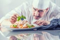 Chef in restaurant kitchen prepares and decorates meal with hands.Cook preparing spaghetti bolognese Royalty Free Stock Photo