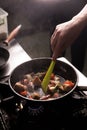 Chef In Restaurant Kitchen Preparing Food dark background Royalty Free Stock Photo