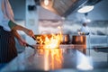 Chef in restaurant kitchen at stove and pan cooking flambe on food Royalty Free Stock Photo