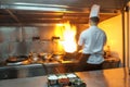 Chef in restaurant kitchen at stove with pan Royalty Free Stock Photo