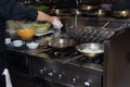 Chef in restaurant kitchen at stove with pan, doing flambe on food. low ligth selective focus. Royalty Free Stock Photo