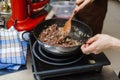 The chef roasts the mince in a deep pan. Ready stuffing with onions in a bowl on the background of spices and greens