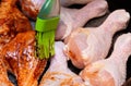 The chef`s hand with a brush spreads the chicken meat with spices and prepares the ingredients for cooking