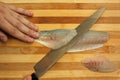 Chef`s hand cutting fish into thin slices with a knife. Royalty Free Stock Photo