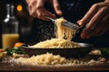 A chef\'s hand grating fresh Parmesan cheese over a bowl of pasta