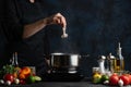 The chef`s hand puts fresh octopus into the pot with boiling water for preparing traditional asian dish for dinner. Backstage of Royalty Free Stock Photo