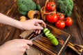 chef& x27;s hands chopping cucumber on a cutting board. Fresh vegetables and dry buckwheat on a wooden table. Organic farmers