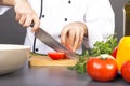 Chef's hands cutting red fresh tomato Royalty Free Stock Photo