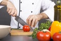 Chef's hands cutting red fresh tomato Royalty Free Stock Photo