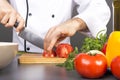 Chef's hands cutting red fresh tomato Royalty Free Stock Photo