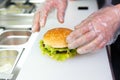 The chef`s hands demonstrate the finished Burger