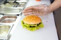 The chef`s hands demonstrate the finished Burger