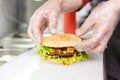 The chef`s hands demonstrate the finished Burger
