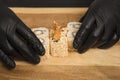 ChefÃ¢â¬â¢s hands in gloves near Japanese Ebi Tempura sushi roll with black tiger shrimp inside. Man holds food in hands.