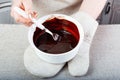 The chef`s hands in potholders hold hot liquid chocolate and mix it Royalty Free Stock Photo