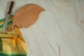 A chef`s knife, a cutting board and a beautiful yellow-green linen tablecloth napkin on a pastel green marble background. Royalty Free Stock Photo