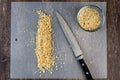 ChefÃ¢â¬â¢s knife and a pile of chopped raw walnuts on a plastic cutting mat, small glass bowl with chopped nuts Royalty Free Stock Photo