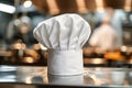 A chef& x27;s white hat stands on a counter in a bustling kitchen. Ai generation Royalty Free Stock Photo