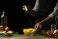 Chef salting french fries on a background with vegetables. Cooking tasty but harmful food Royalty Free Stock Photo