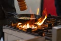 Chef seasoning a pan of food over flames Royalty Free Stock Photo